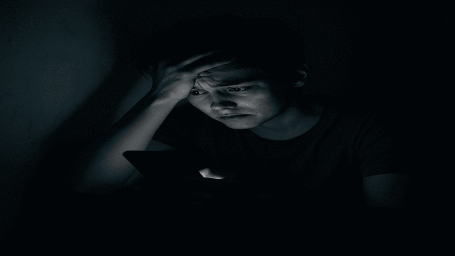 Person feeling overwhelmed by social media use at night