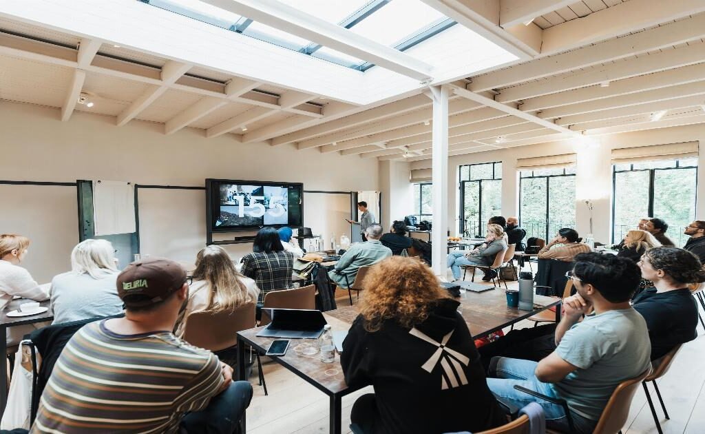 A diverse group of professionals engaged in a collaborative discussion around a conference table, with expressions of engagement and mutual respect