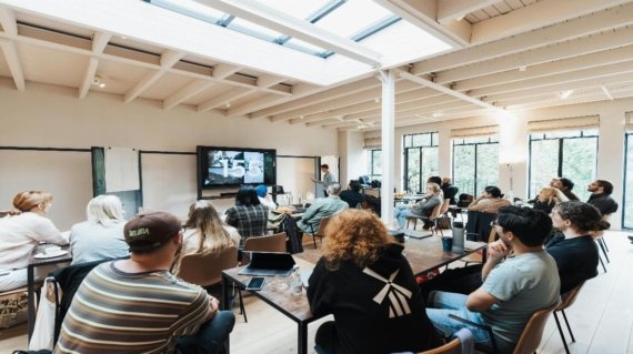A diverse group of professionals engaged in a collaborative discussion around a conference table, with expressions of engagement and mutual respect