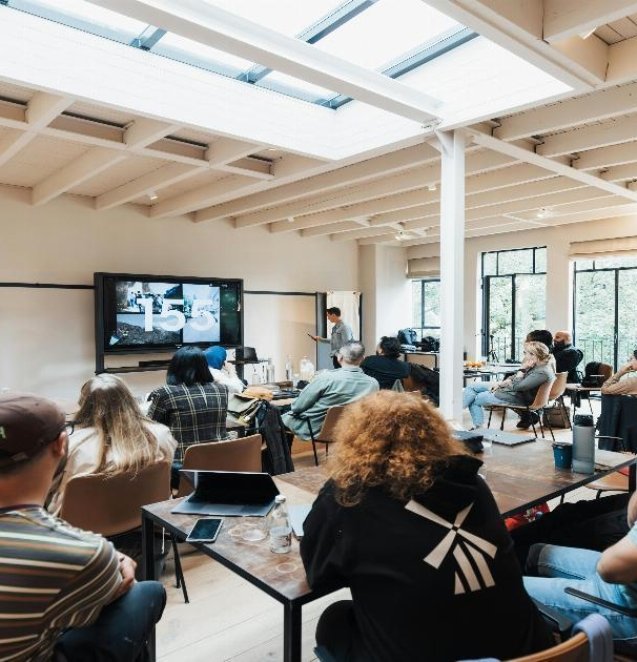 A diverse group of professionals engaged in a collaborative discussion around a conference table, with expressions of engagement and mutual respect
