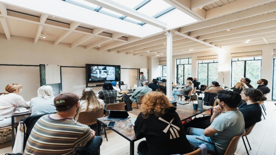 A diverse group of professionals engaged in a collaborative discussion around a conference table, with expressions of engagement and mutual respect