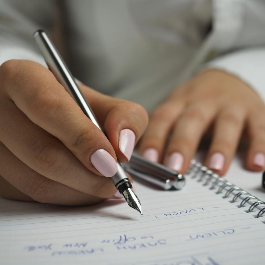 A detailed image of handwriting in a notebook with a fountain pen and glasses, ideal for office themes.