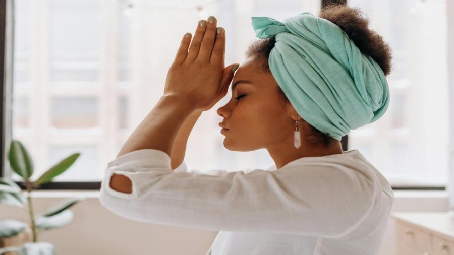 Woman practicing meditation indoors with a focus on relaxation and mindfulness.