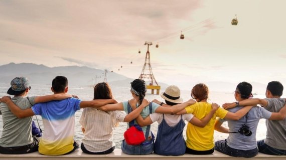 people holding shoulders sitting on wall
