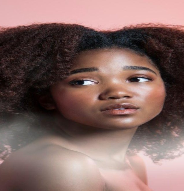 a woman with an afro is looking at the camera