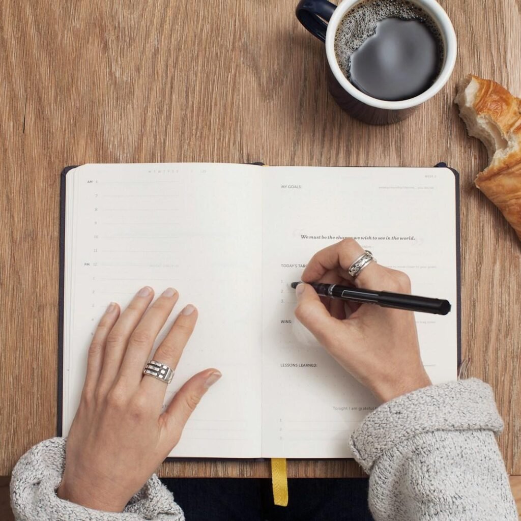 person with bipolar disorder writing in a mood-tracking planner as part of a daily routine