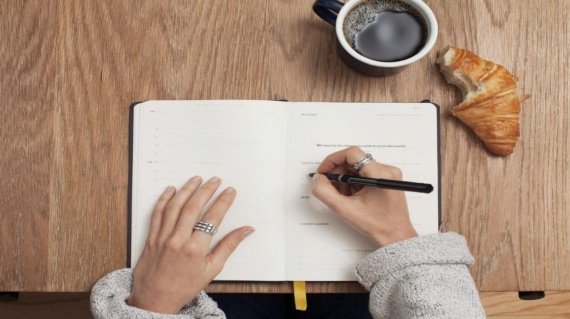 person writing on a book