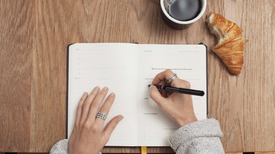 person writing on a book
