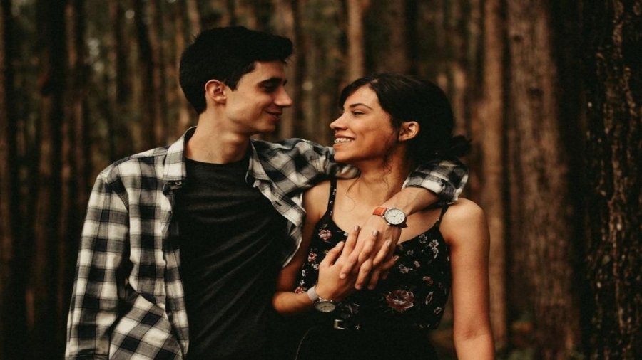 man wrapping arm on woman facing each other