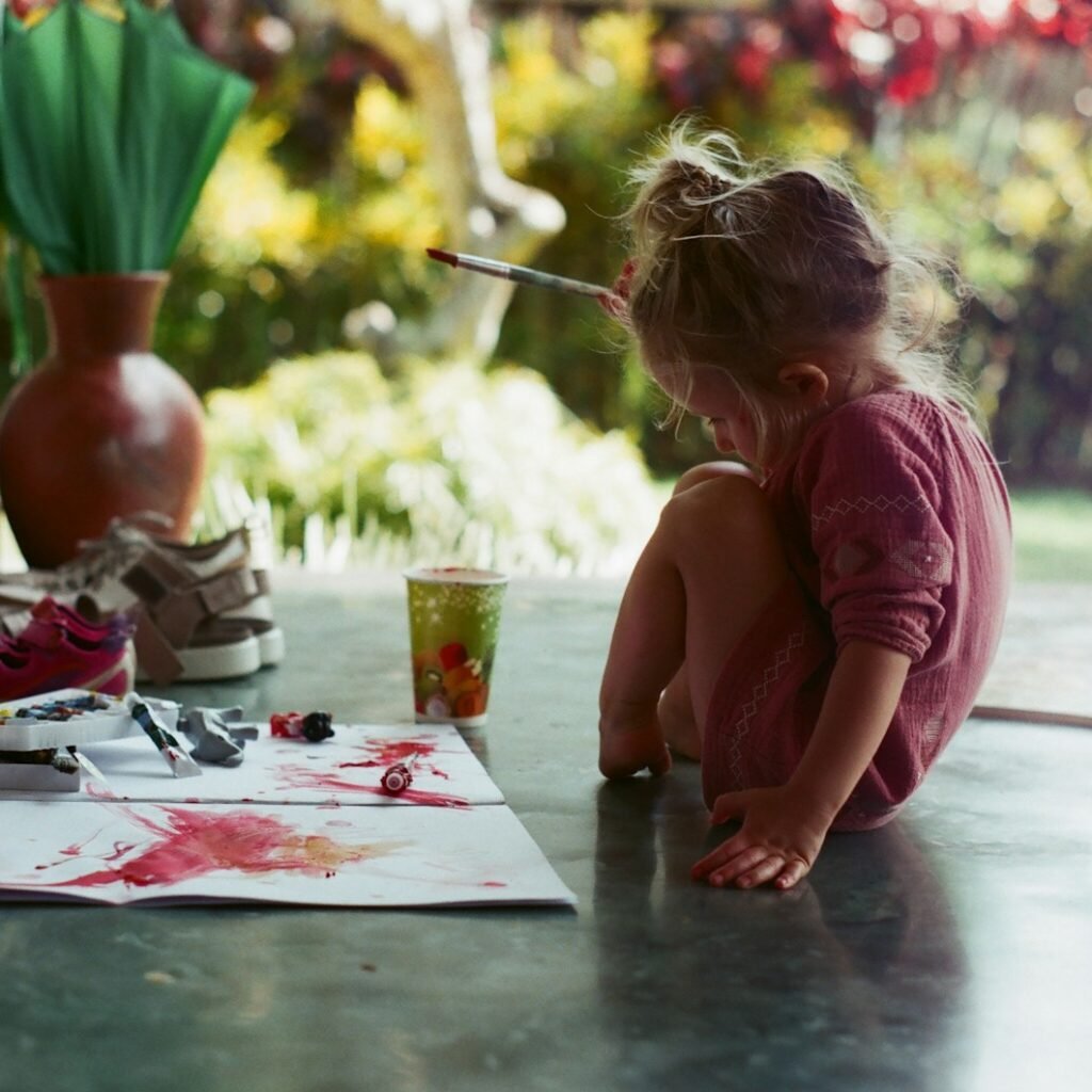 girl in pink shirt sitting on floor while writing