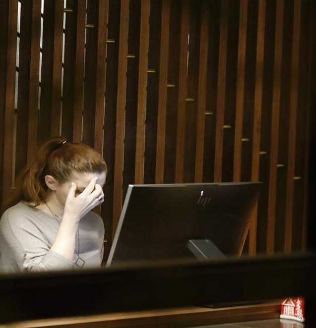 a woman sitting in front of a laptop computer