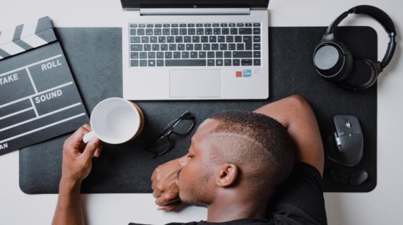 a man sitting at a desk with a laptop and headphones