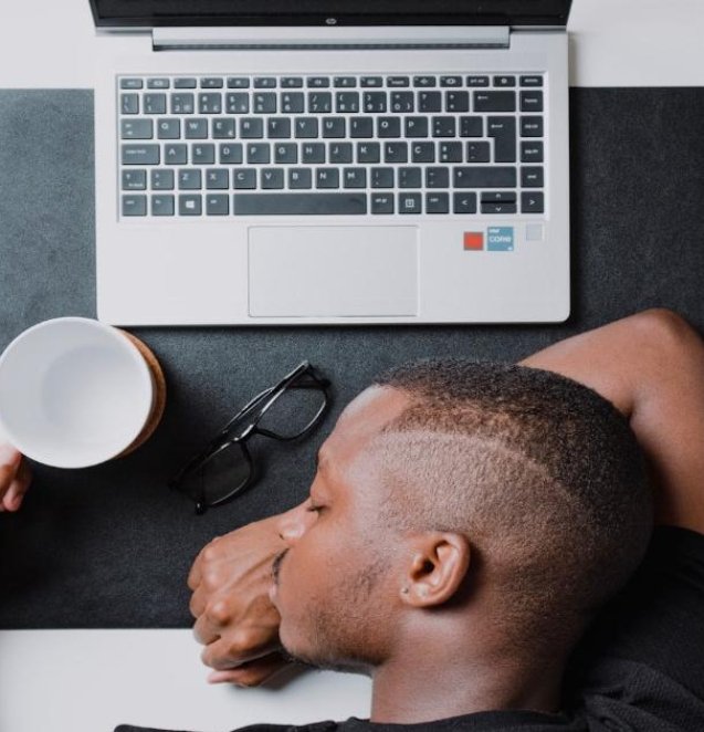 a man sitting at a desk with a laptop and headphones