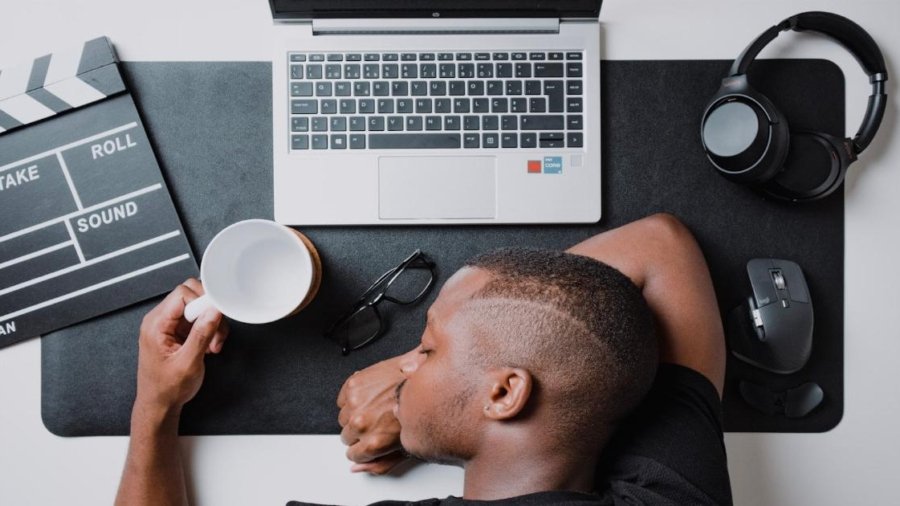 a man sitting at a desk with a laptop and headphones